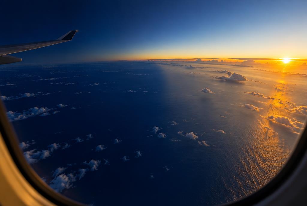 Dawn over the Pacific seen through an airplane window